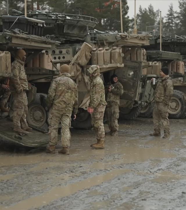 US-Soldaten vor Militärfahrzeugen