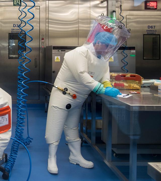 Zwei Menschen in Schutzanzügen arbeiten in einem Labor