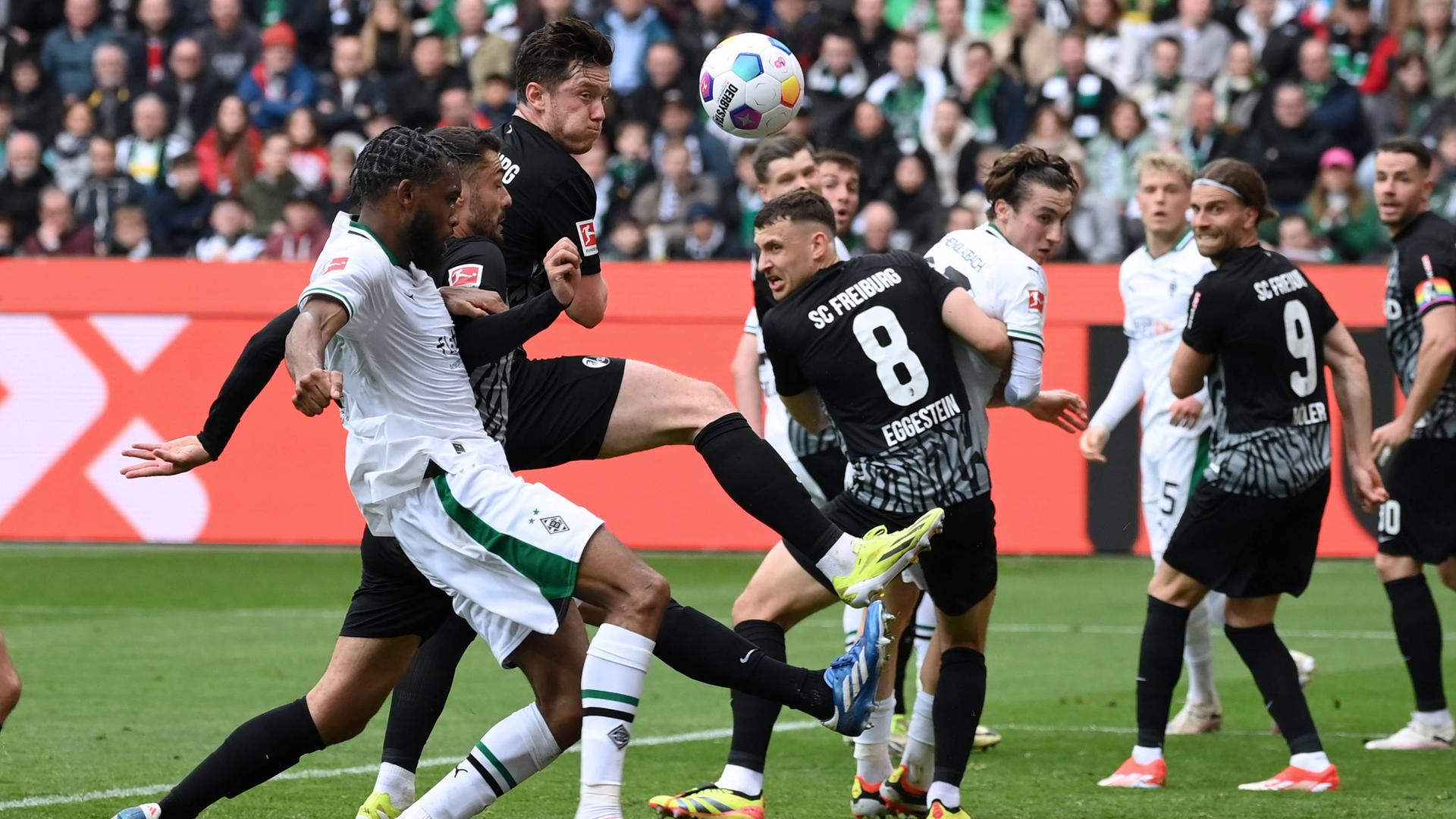 Gladbachs Theoson Jordan Siebatcheu und Freiburgs Manuel Gulde und Michael Gregoritsch im Kampf um den Ball am 30.03.2024.