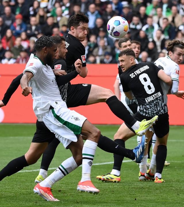 Gladbachs Theoson Jordan Siebatcheu und Freiburgs Manuel Gulde und Michael Gregoritsch im Kampf um den Ball am 30.03.2024.