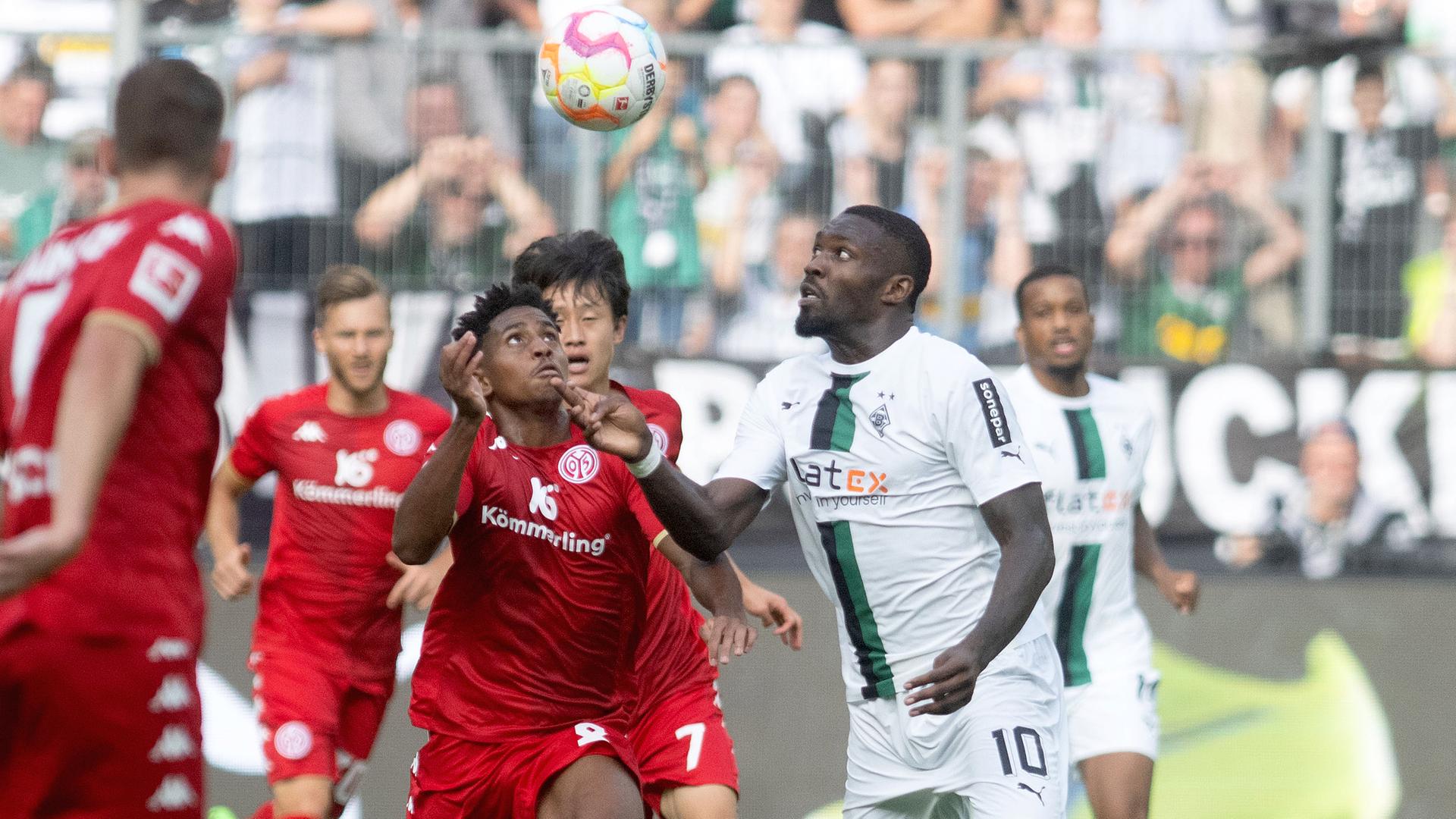 Mönchengladbachs Marcus Thuram und Leandro Barreiro von Mainz kämpfen um den Ball am 04.09.2022 in Mönchengladbach.