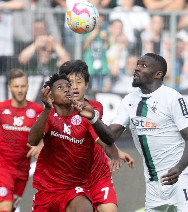 Mönchengladbachs Marcus Thuram und Leandro Barreiro von Mainz kämpfen um den Ball am 04.09.2022 in Mönchengladbach.
