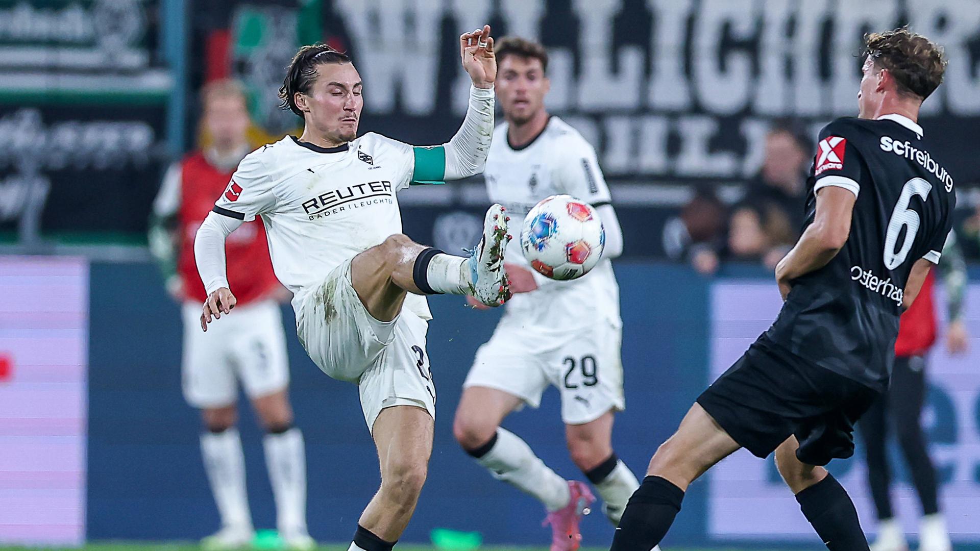 Rocco Reitz (Borussia Mönchengladbach 27) und Patrick Osterhage (SC Freiburg 06) kämpfen. 