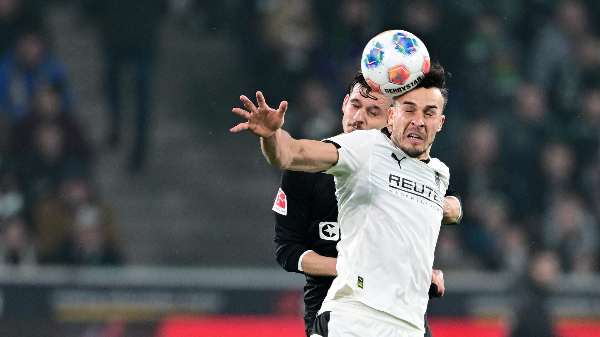 Adam Dzwigala (St. Pauli) und Haris Tabakovic (Gladbach) im Kopfballduell am 13.03.2026 in Mönchengladbach. 