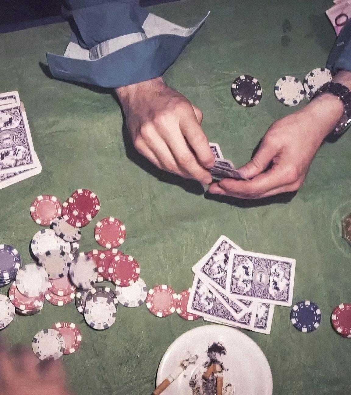 Blick von oben auf einen Tisch: Auf dem Tisch liegen neben Händen, die Spielkarten halten, weitere Spielkarten und Pokerchips. Daneben stehen Gläser und ein Aschenbecher.