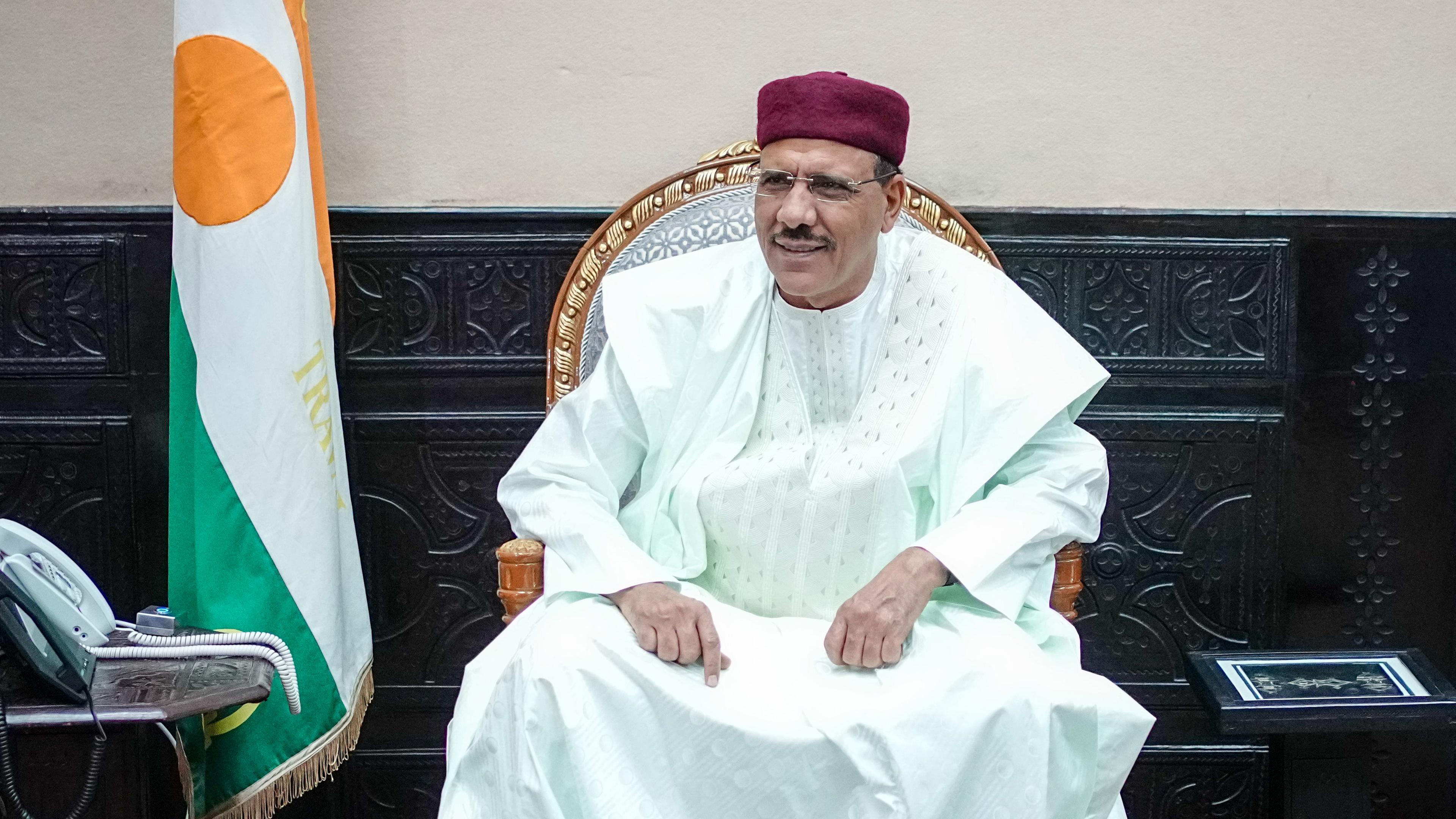 Mohamed Bazoum, Staatspräsident der Republik Niger sitzt auf einem Sessel.