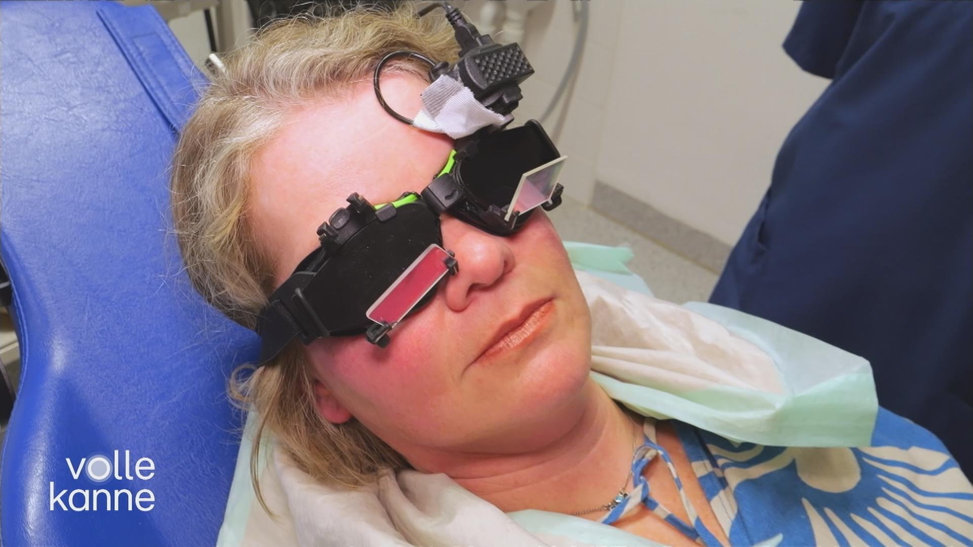 Frau mit medizinischem Instrument auf den Augen auf einer Arztliege