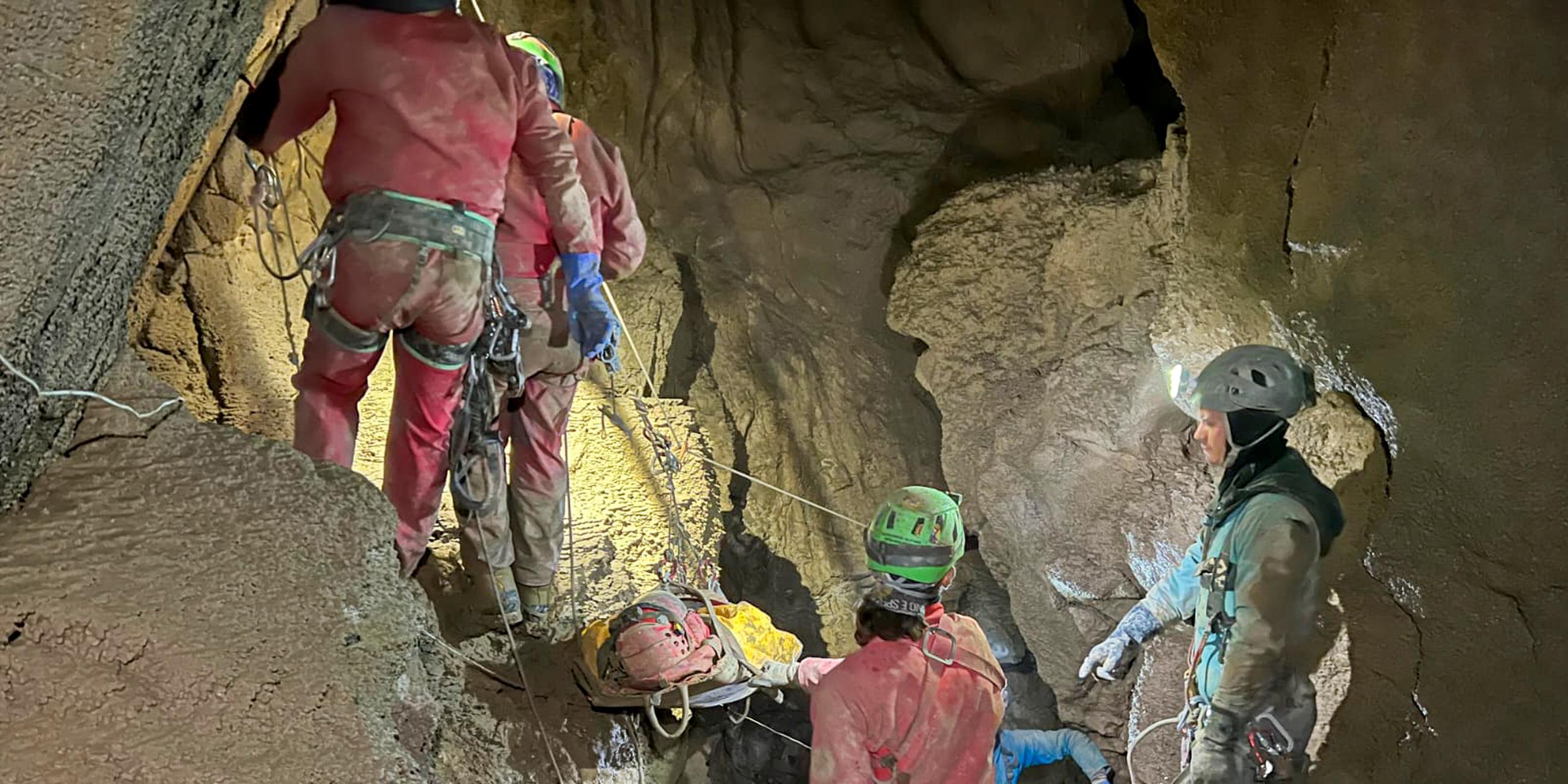Mehrere Rettungskräfte bergen den verletzten Forscher aus einer Höhle