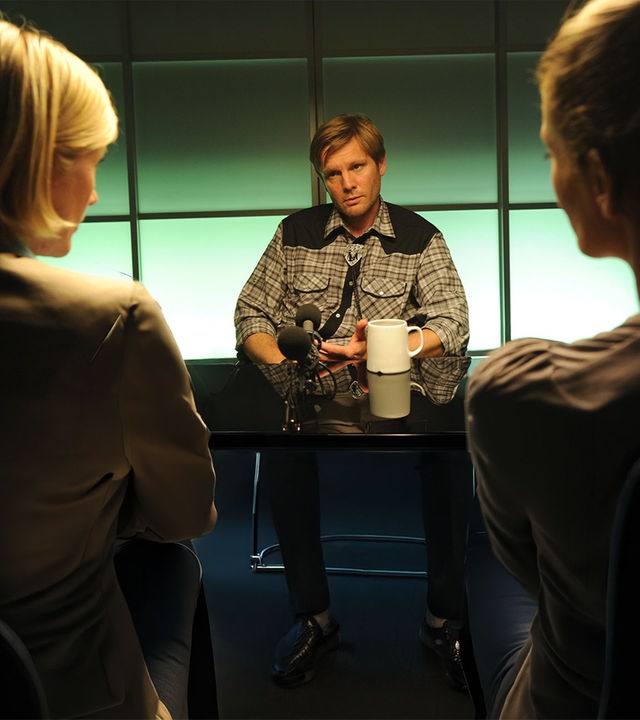 Martina Seiffert (Astrid M. Fünderich) und Selma Kirsch (Yve Burbach) sitzen Bastian Hölzner (Kai Ivo Baulitz) im Vernehmungsraum gegenüber. Hölzner blickt entspannt zu Martina.