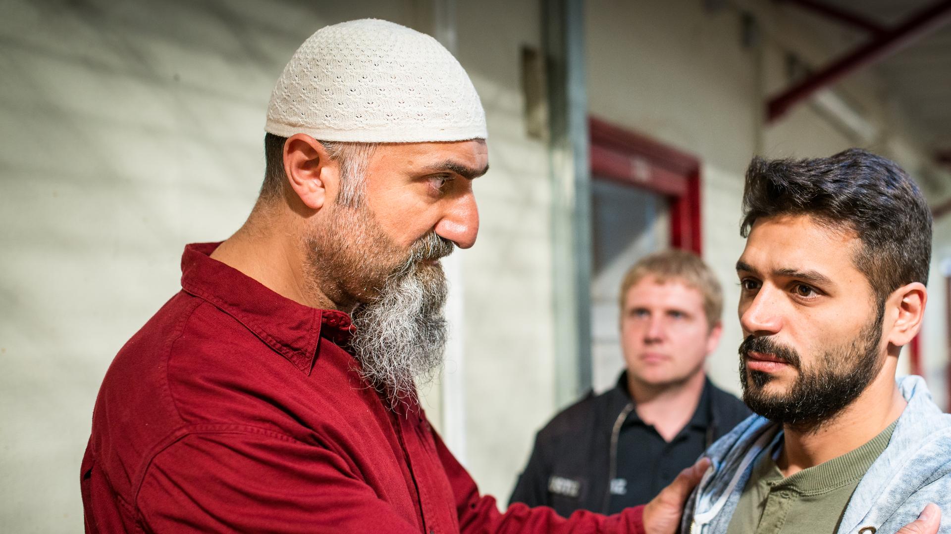 "Notruf Hafenkante - Morgenland": In einem Gefängnisgang stehen Imam Adil (Yilmaz Atmaca) und Mustafa (Tamer Arslan) nebeneinander.