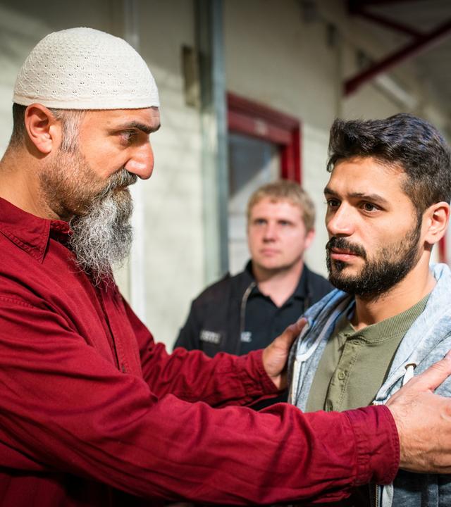 "Notruf Hafenkante - Morgenland": In einem Gefängnisgang stehen Imam Adil (Yilmaz Atmaca) und Mustafa (Tamer Arslan) nebeneinander.