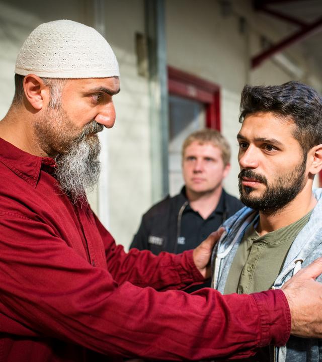 "Notruf Hafenkante - Morgenland": In einem Gefängnisgang stehen Imam Adil (Yilmaz Atmaca) und Mustafa (Tamer Arslan) nebeneinander.