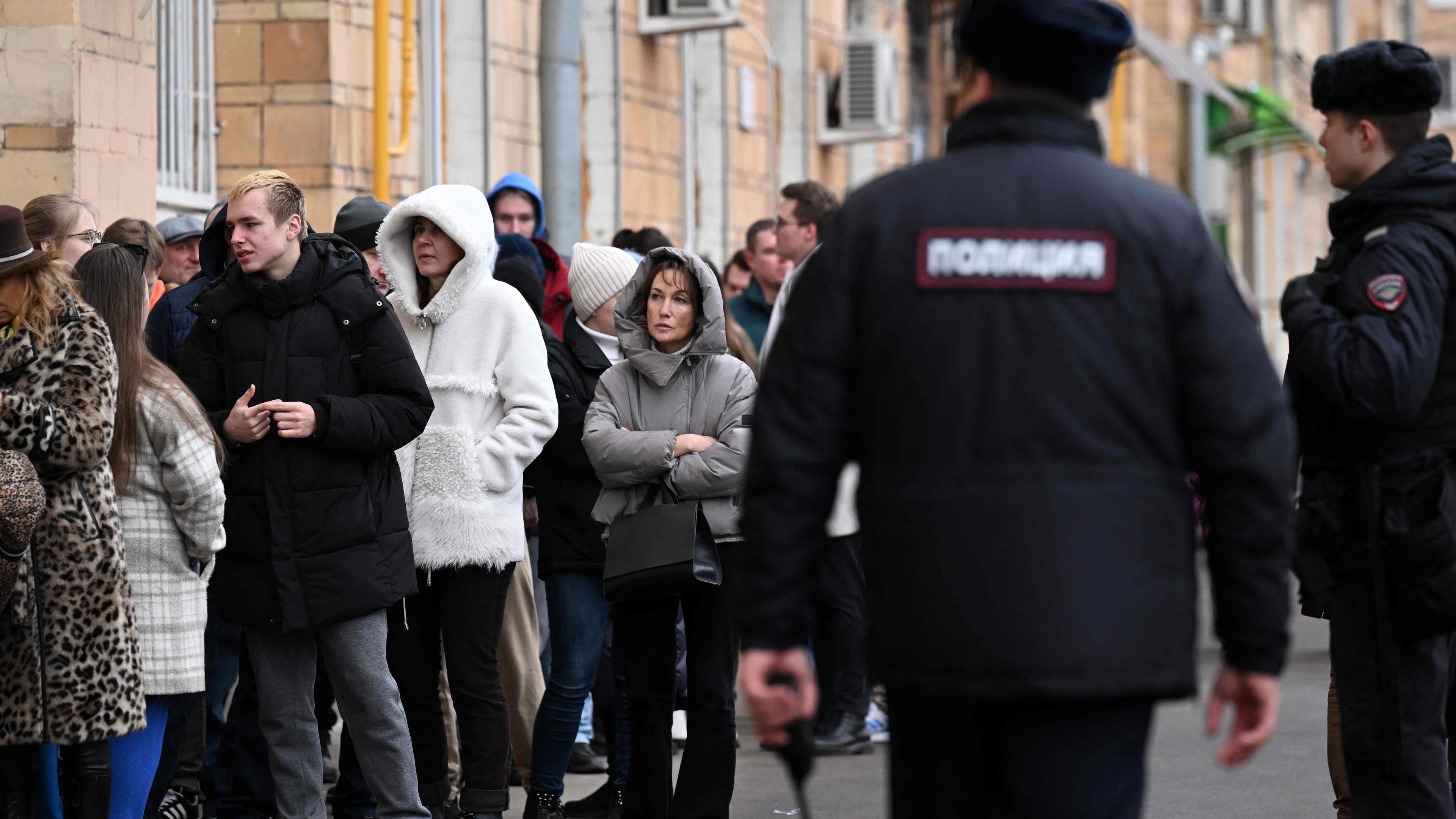Meschen stehen in einer Warteschlange vor einem Wahllokal in Moskau