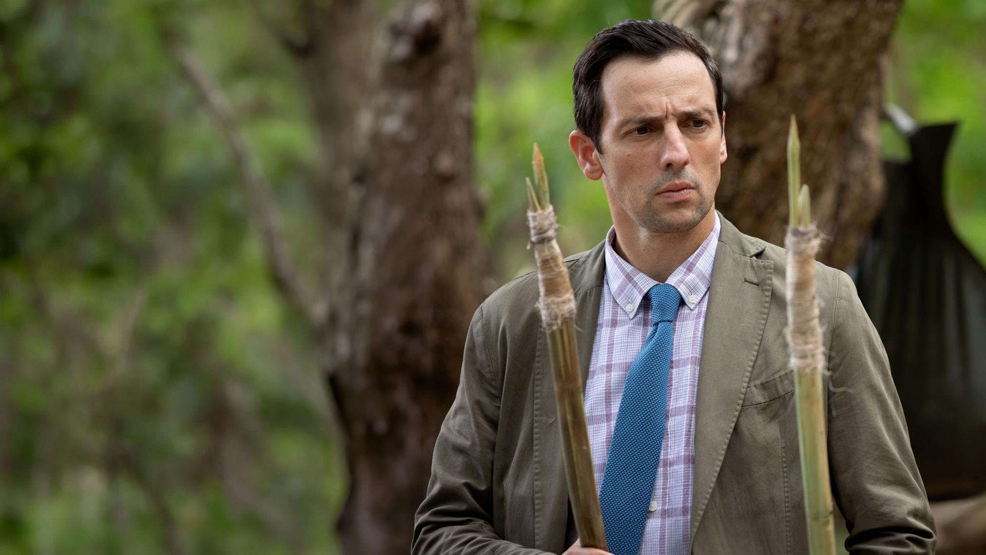 "Death in Paradise - Mosquito Island": Detektive Neville Parker (Ralf Little) schaut konzentriert auf zwei Speere.