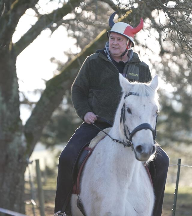 Waldi sitzt auf einem Pferd.