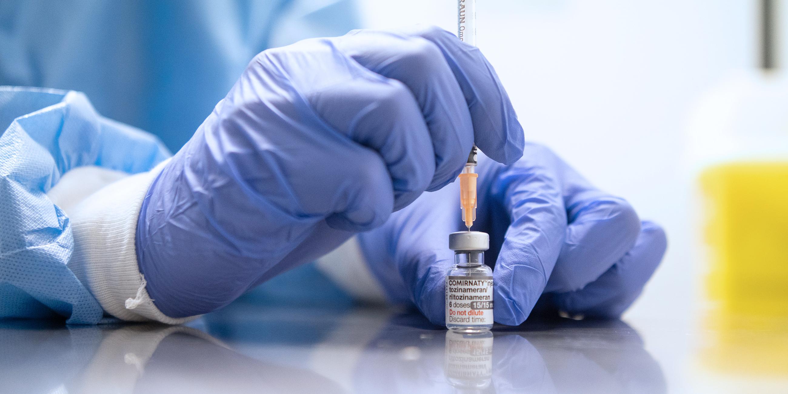 Spritze wird mit mRNA-Impfstoff von Biontech aufgefüllt