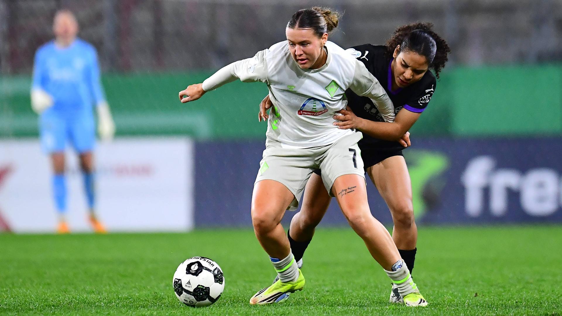 Bremens Stürmerin Larissa Michelle Mühlhaus wird von hinten im Zweikampf von Essens Verteidigerin Ella Touon bedrängt