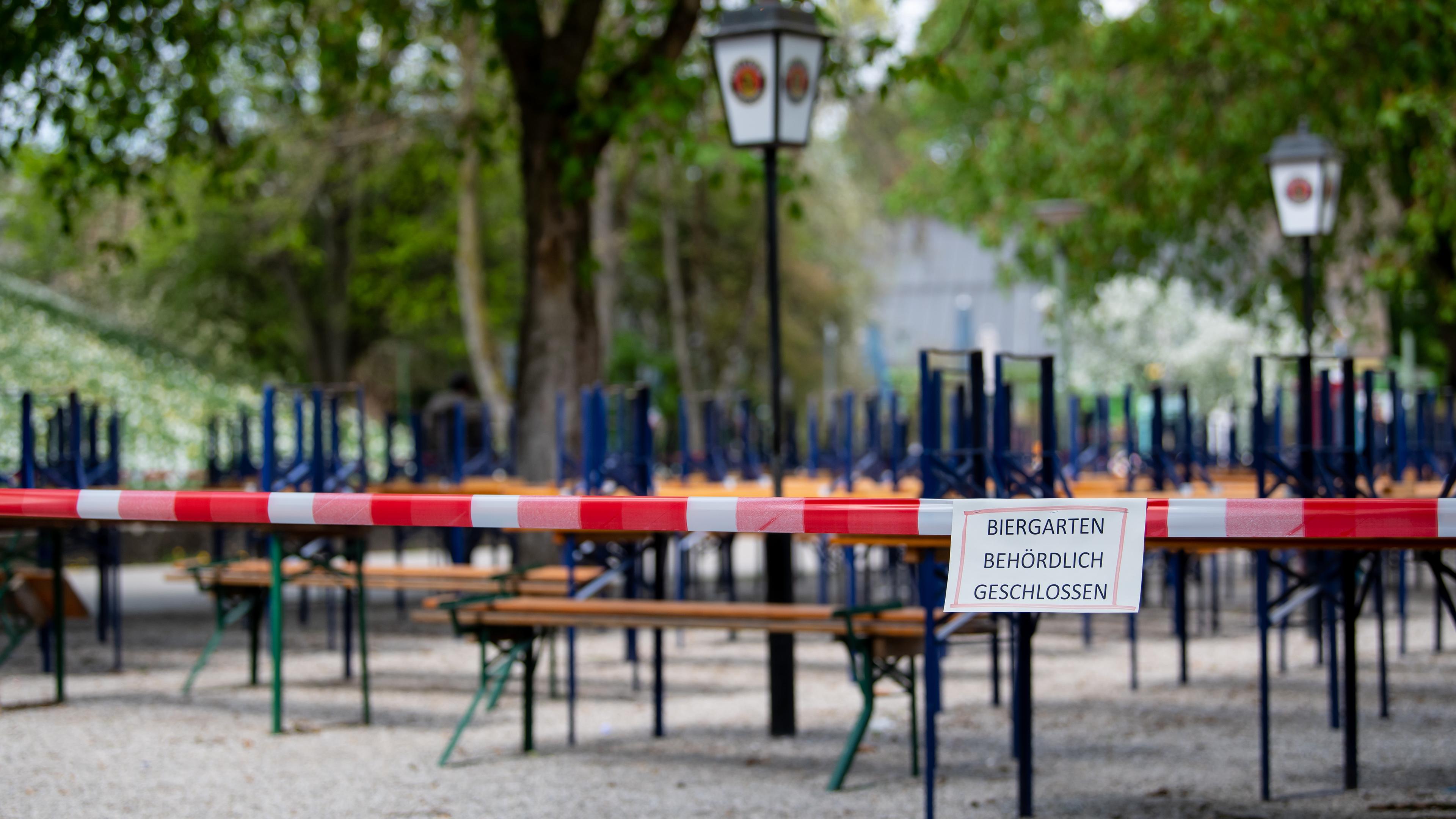 Bayern, München: Menschenleer zeigt sich ein Biergarten mit gestapelten Bänken und Tischen im Westpark. Archivbild