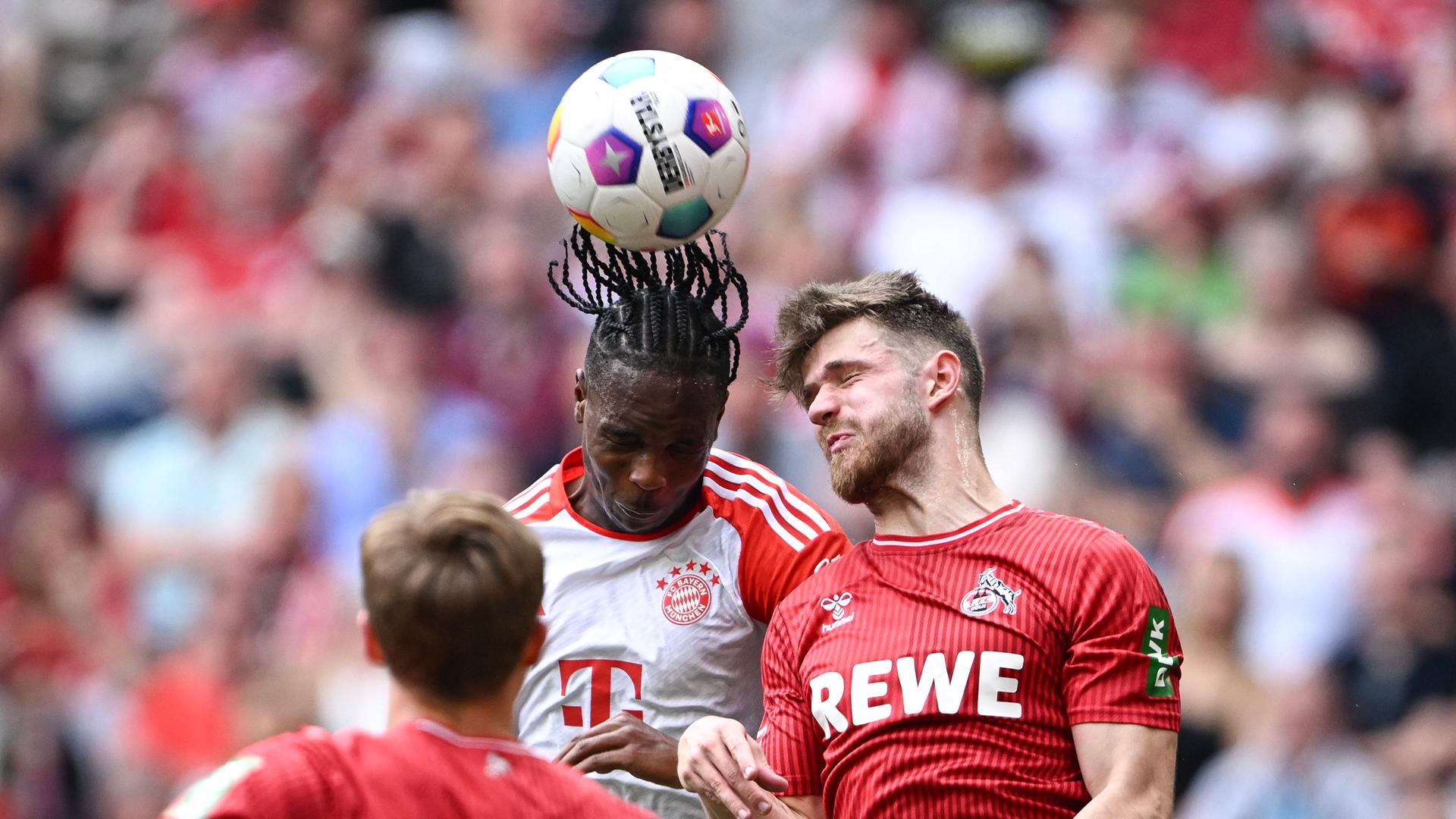 Mathys Tel (Mitte, FC Bayern München) gegen Jan Thielmann (r., 1. FC Köln).