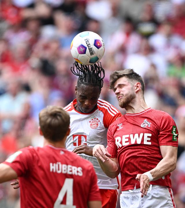 Mathys Tel (Mitte, FC Bayern München) gegen Jan Thielmann (r., 1. FC Köln).
