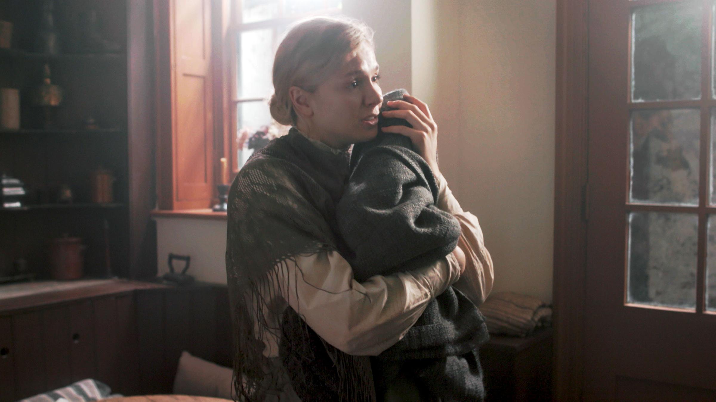 "Murder Maps: Die gierige Pflegemutter": Spielszene: Evelina Marmon (Darstellerin unbekannt) hält ein in eine Decke gewickeltes Baby auf dem Arm - auf der Suche nach einer Pflegemutter für ihre Tochter.