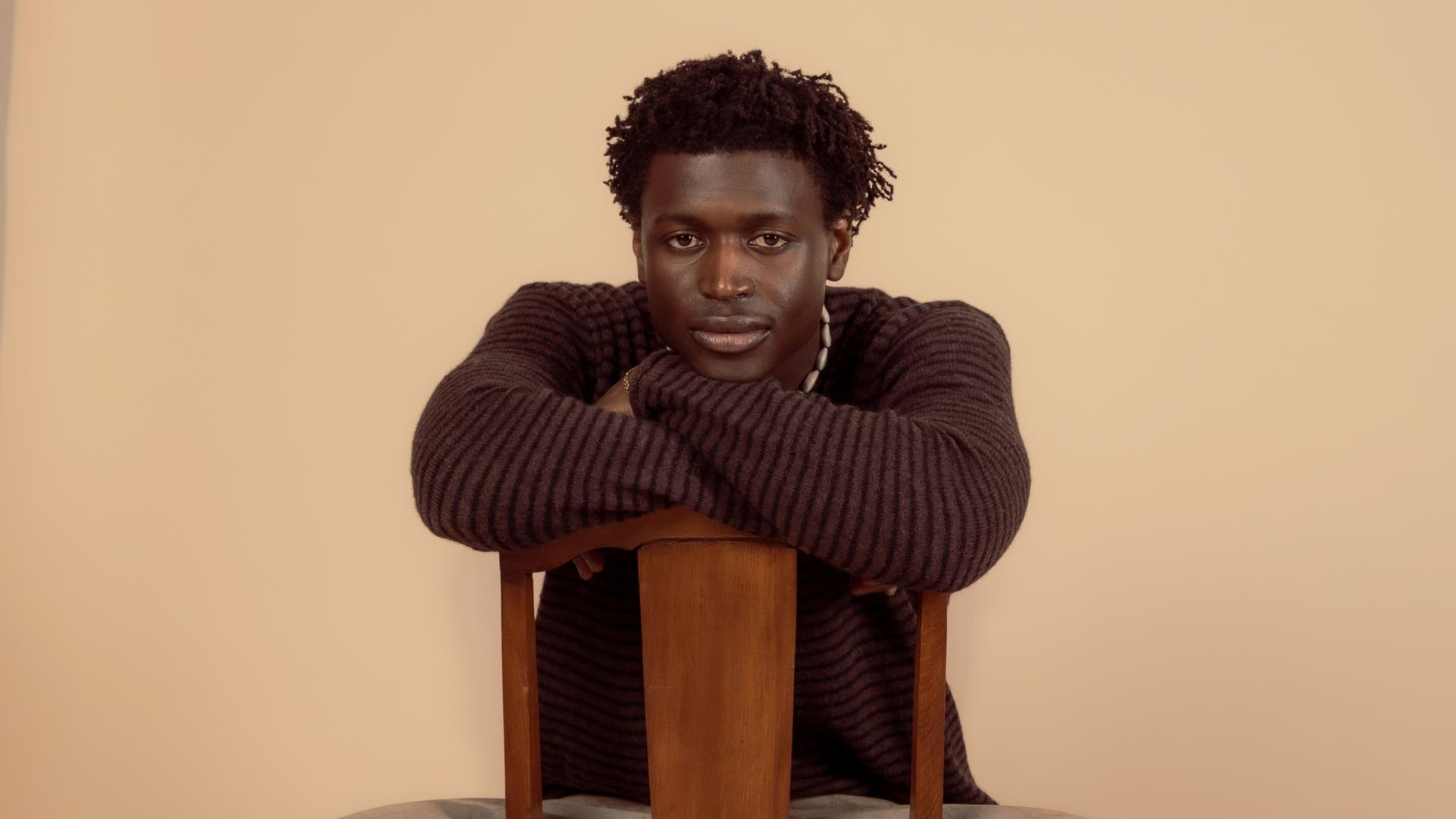 Man sieht einen Mann der auf einem Stuhl sitzen.