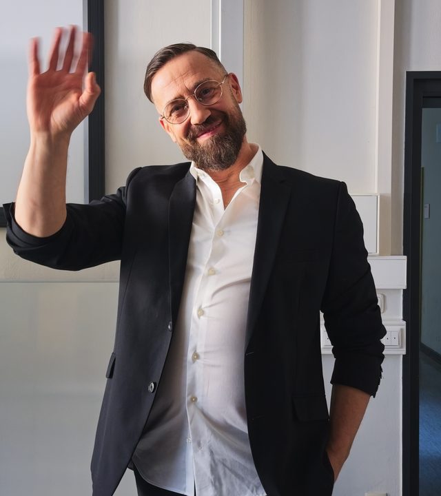 Bürger Lars Dietrich  in Sakko winkt in die Kamera.