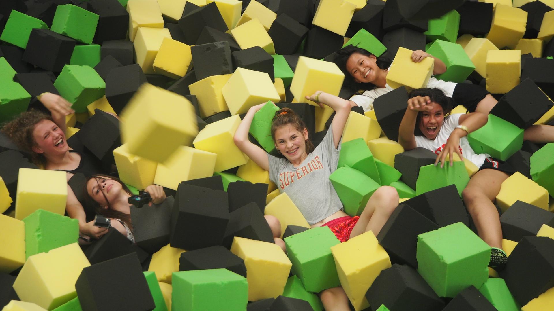 Die Mädchen zwischen großen Schaumklötzen in der Trampolinhalle