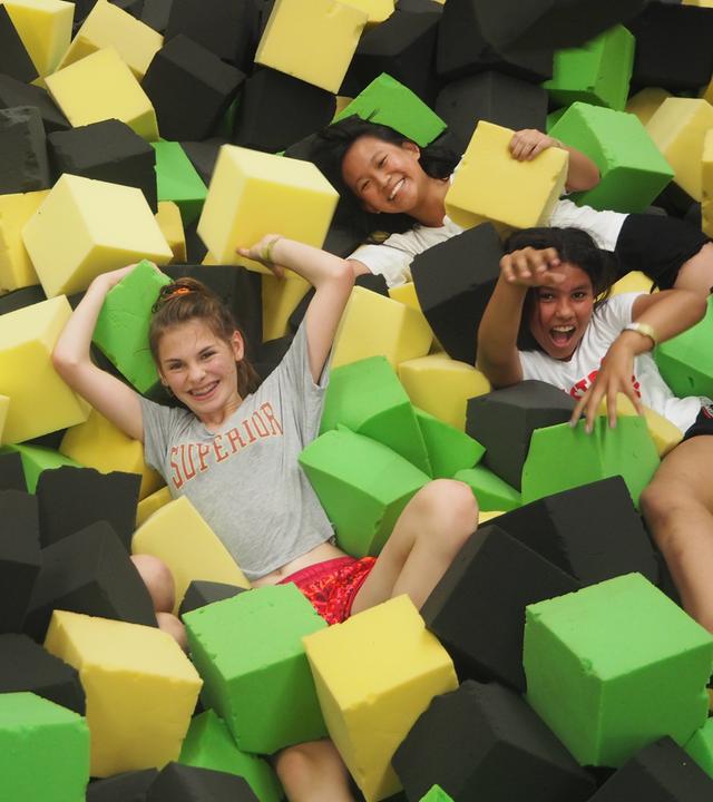 Die Mädchen zwischen großen Schaumklötzen in der Trampolinhalle