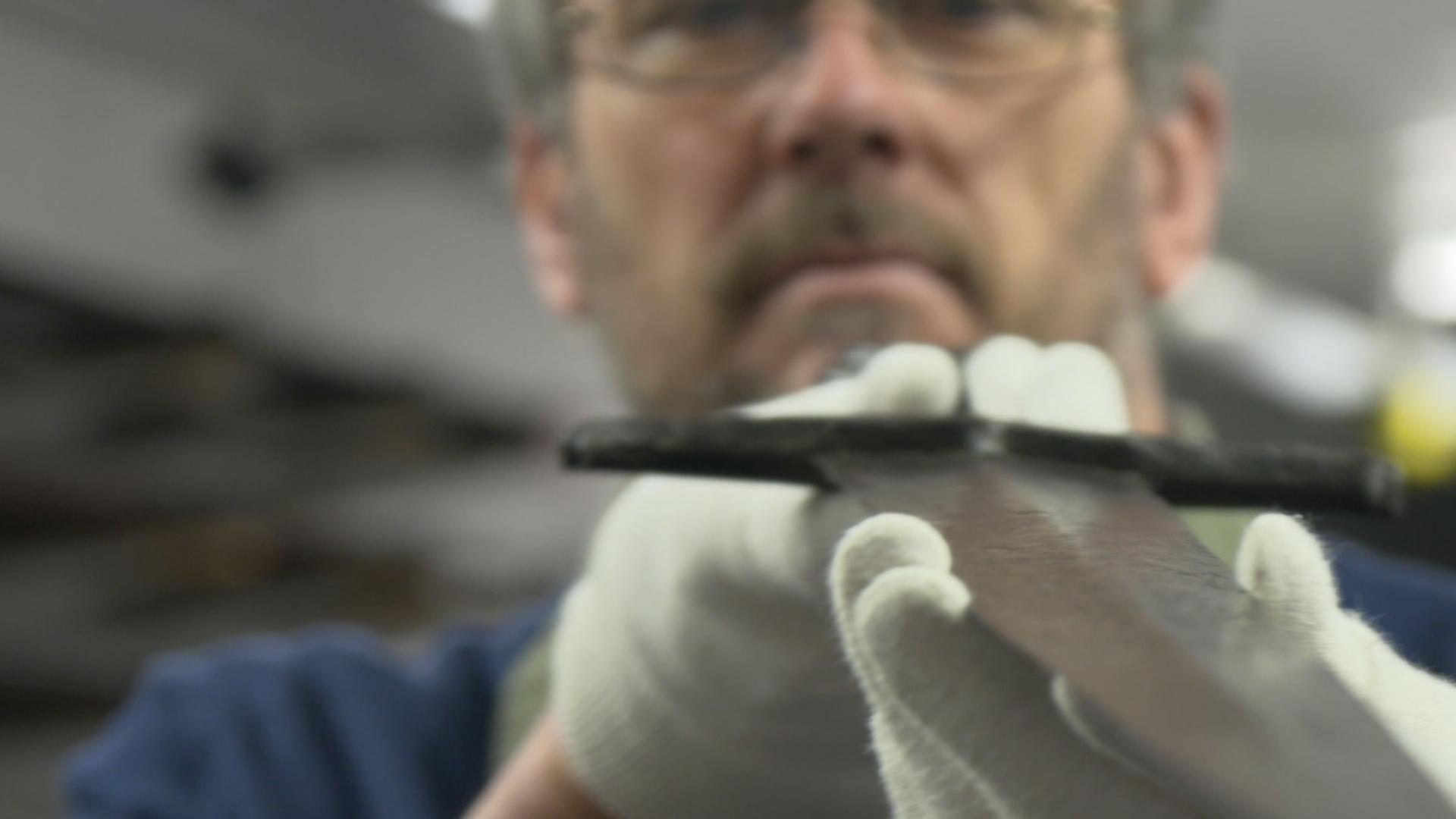 "Mysterien des Mittelalters - Die Schwerter von Castillon": Archäologe Tim Sutherland untersucht ein Castillon-Schwert, Sammlung der Royal Armouries, Leeds, England - hält das Schwert vor sich, prüft die Klinge.