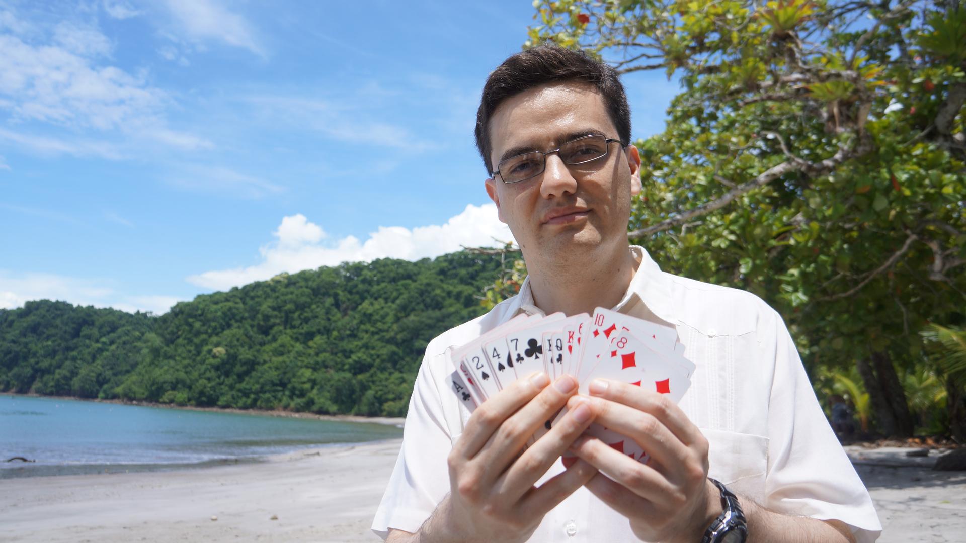 "Mysterien des Weltalls: Sind wir alle Aliens?": Andrew Siemion, Spezialist für außerirdische Intelligenz am UC Berkeley's SETI Research Center, steht am Strand und hält ein Deck Spielkarten in den Händen.