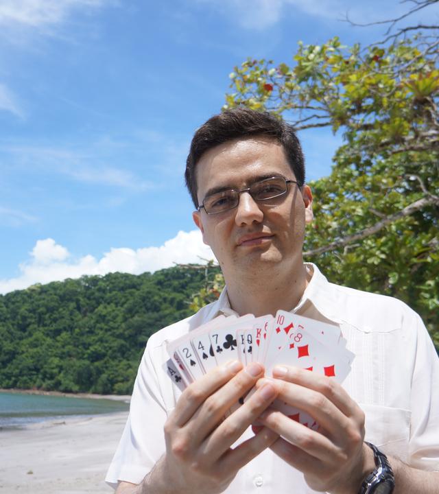 "Mysterien des Weltalls: Sind wir alle Aliens?": Andrew Siemion, Spezialist für außerirdische Intelligenz am UC Berkeley's SETI Research Center, steht am Strand und hält ein Deck Spielkarten in den Händen.