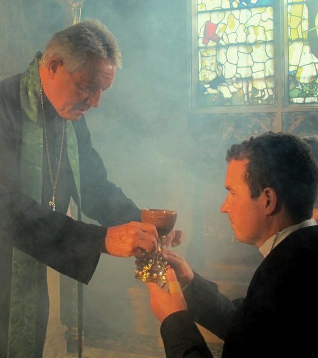 "Mythen-Jäger: Der Kelch von Valencia": Filmszene: Priester gibt die Heilige Kommunion mit dem Kelch von Valencia.