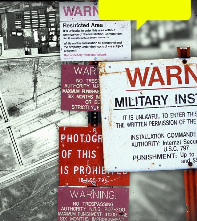 Im Vordergrund mehrere Warnschilder, die im Bereich der Area 51 stehen; im Hintergrund eine Luftaufnahme der Area 51