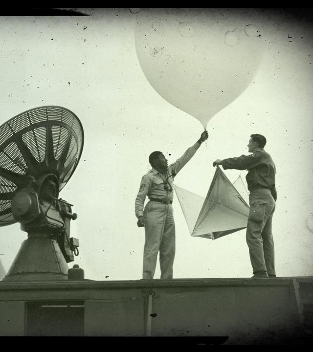 Zwei US-Soldaten lassen vom Dach einer Wetterstation einen Wetterballon steigen.