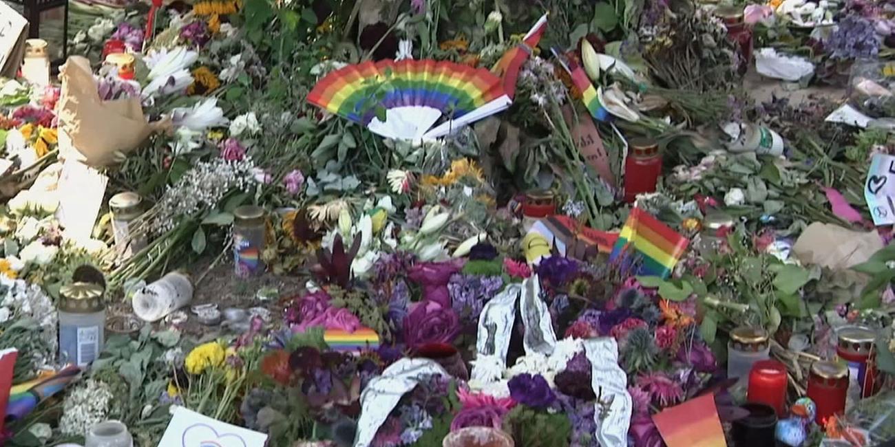 Trauerstelle vom Anschlag auf den CSD Berlin mit vielen Blumen und Regenbögen.