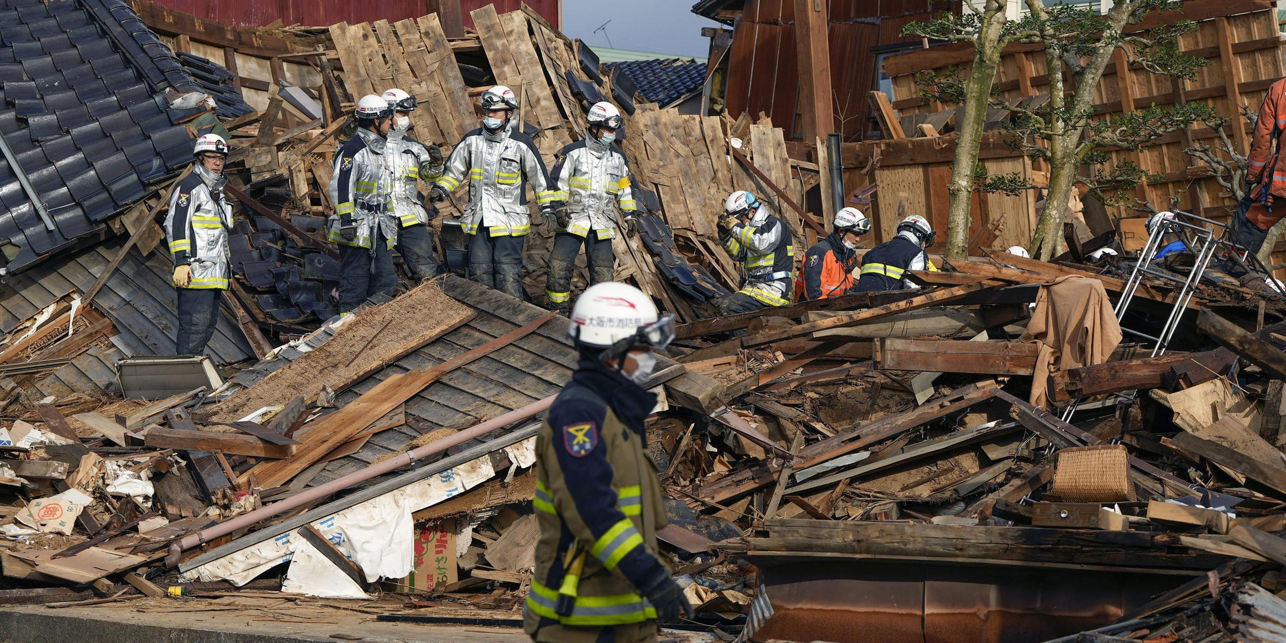 Rettungskräfte arbeiten nach einem starken Erbeben an einem eingestürzten Gebäude. 