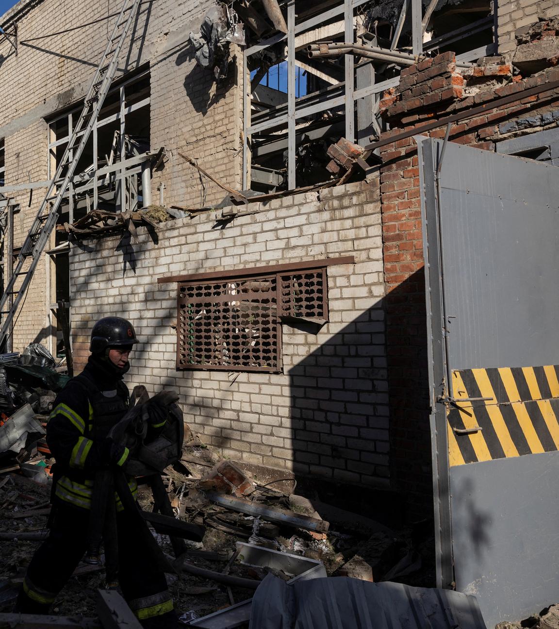 Feuerwehrleute und ein Staatsanwalt für Kriegsverbrechen arbeiten am Standort einer landwirtschaftlichen Gerätefabrik, die während des russischen Angriffs auf die Ukraine am 27. Mai 2024 in Charkiw, Ukraine, von einem russischen Luftangriff getroffen wurde. 