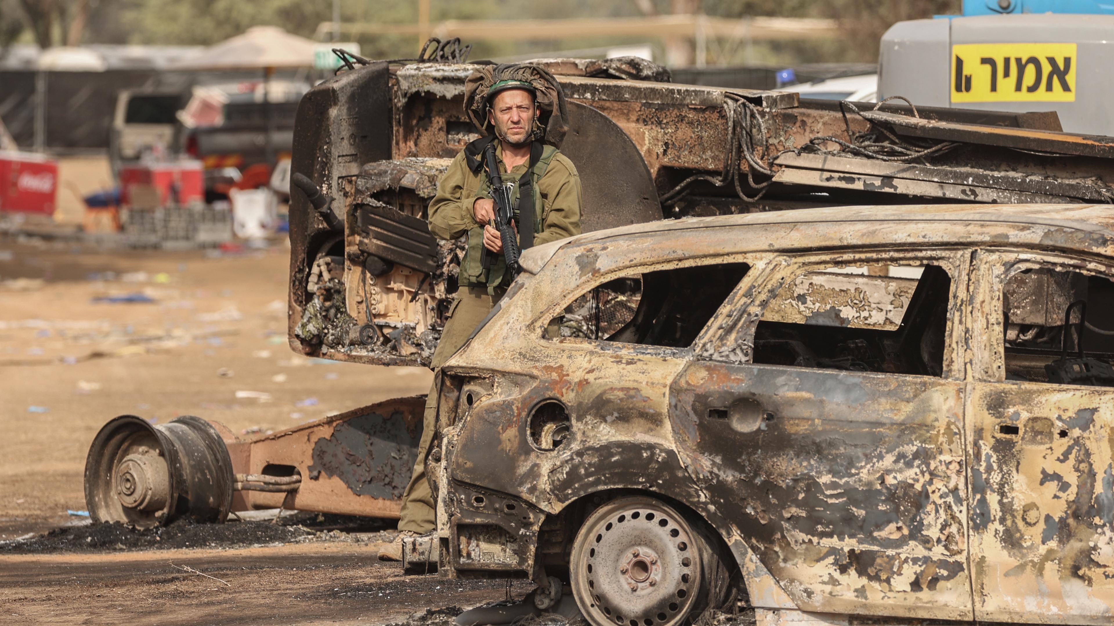 Archiv: Ein israelischer Soldat steht auf dem Gelände des elektronischen Musikfestivals Supernova nach dem tödlichen Angriff islamistischer Hamas-Kämpfer vom 07.10.202