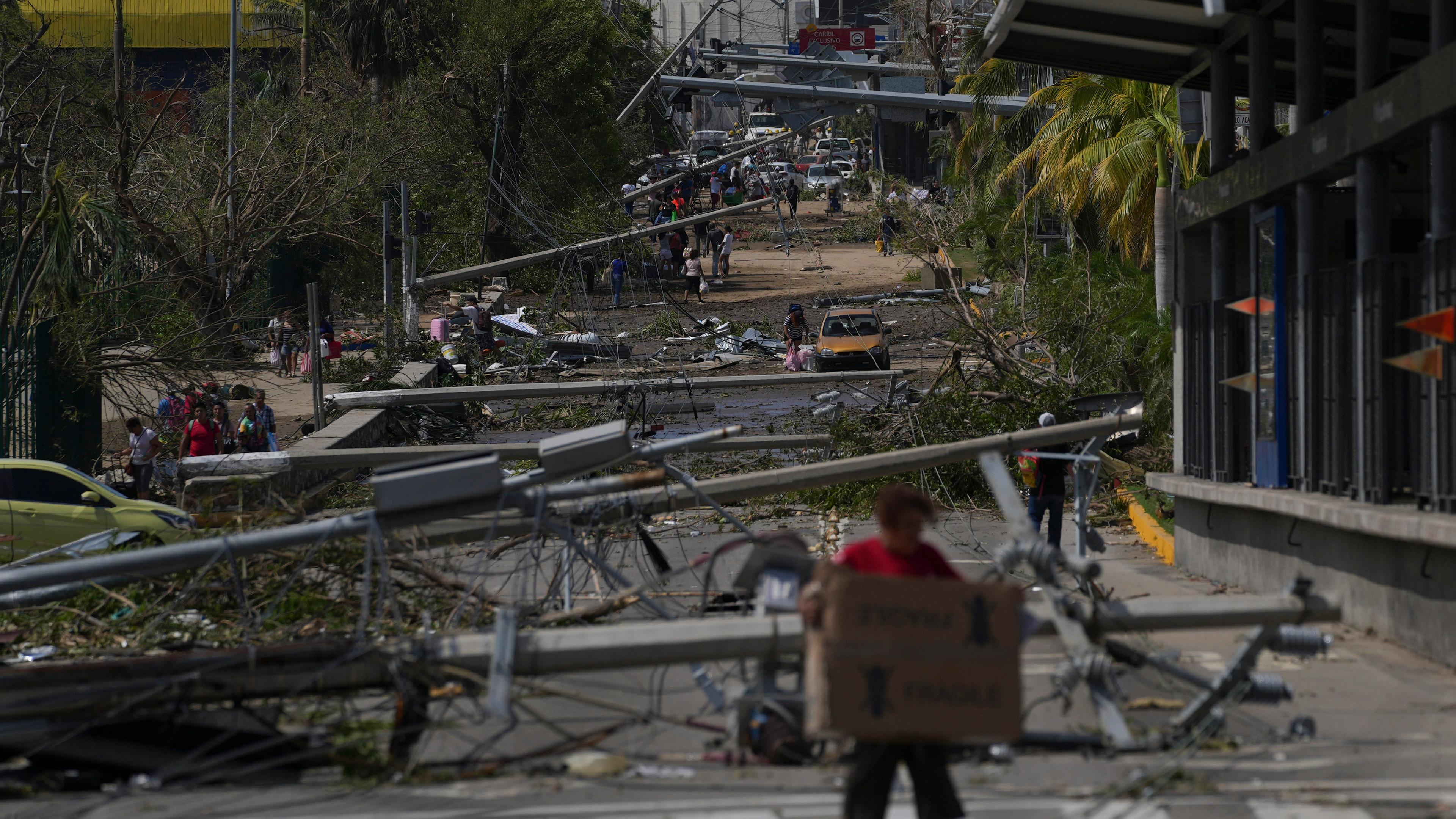 Umgestürzte Strom- und Telefonmasten liegen auf einer Straße, nachdem Hurrikan "Otis" durch Mexiko gewütet ist. 
