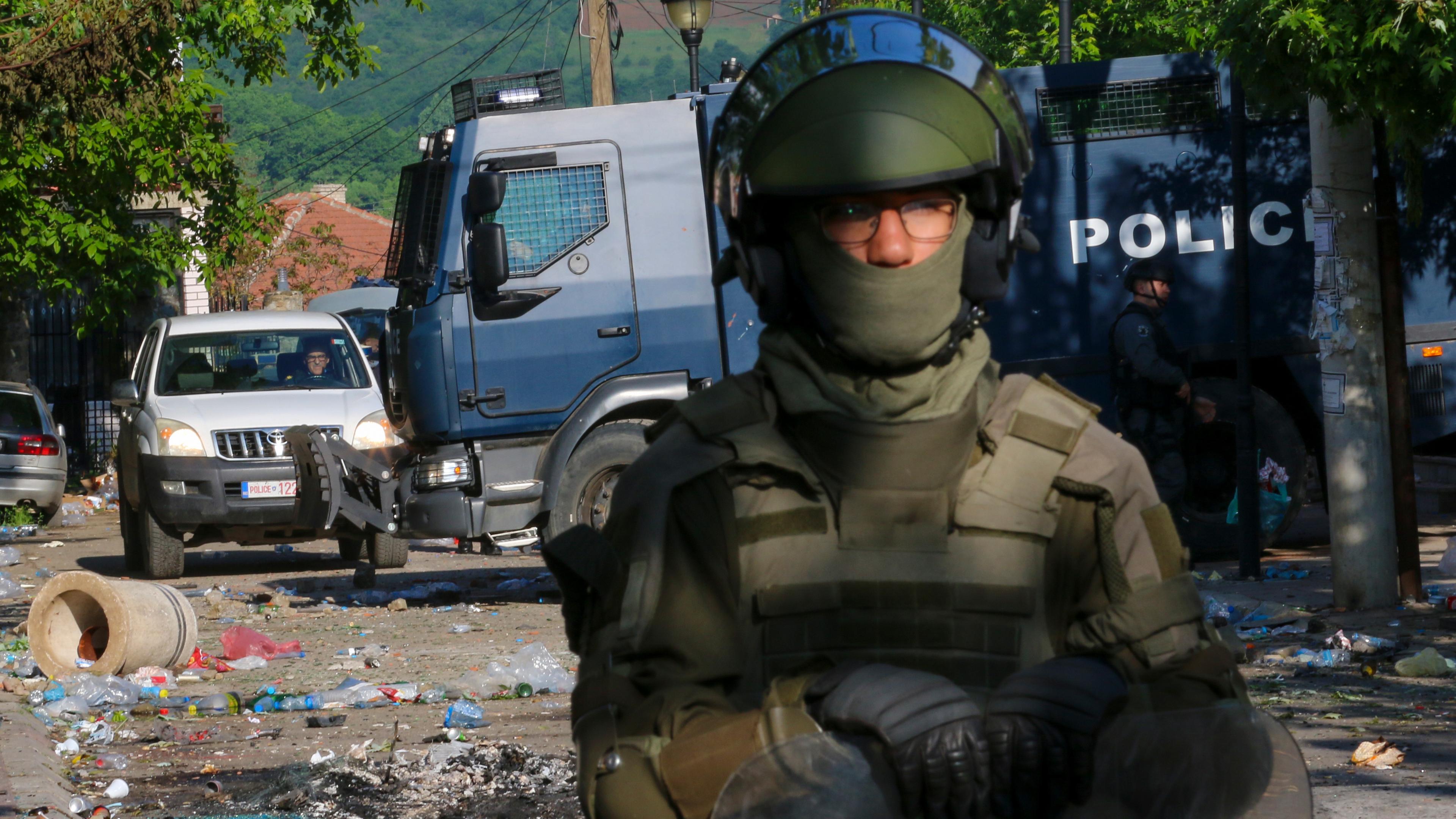 KFOR-Soldaten (vorne) und Kosovo-Polizisten bewachen ein städtisches Gebäude nach den gestrigen Zusammenstößen in der Stadt Zvecan(Kosovo), aufgenommen am 30.05.2023