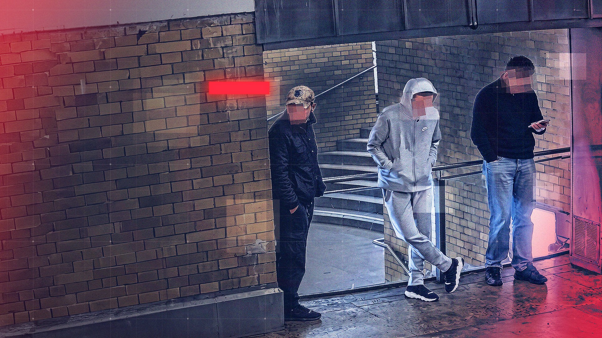 Drei junge Männer stehen in einem überdachten Bereich eines S- und U-Bahnhofes mit Backsteinwänden und Treppenaufgang. Die Gesichter sind verpixelt. Einer von ihnen trägt eine Tarnkappe und dunkle Kleidung, der Zweite einen grauen Trainingsanzug mit Kapuze, der Dritte einen dunklen Pullover und blickt auf ein Smartphone. Die Szene ist eine Aufnahme aus einer Überwachungskamera; rote grafische Overlay-Elemente und Rasterlinien sind über das Bild gelegt.