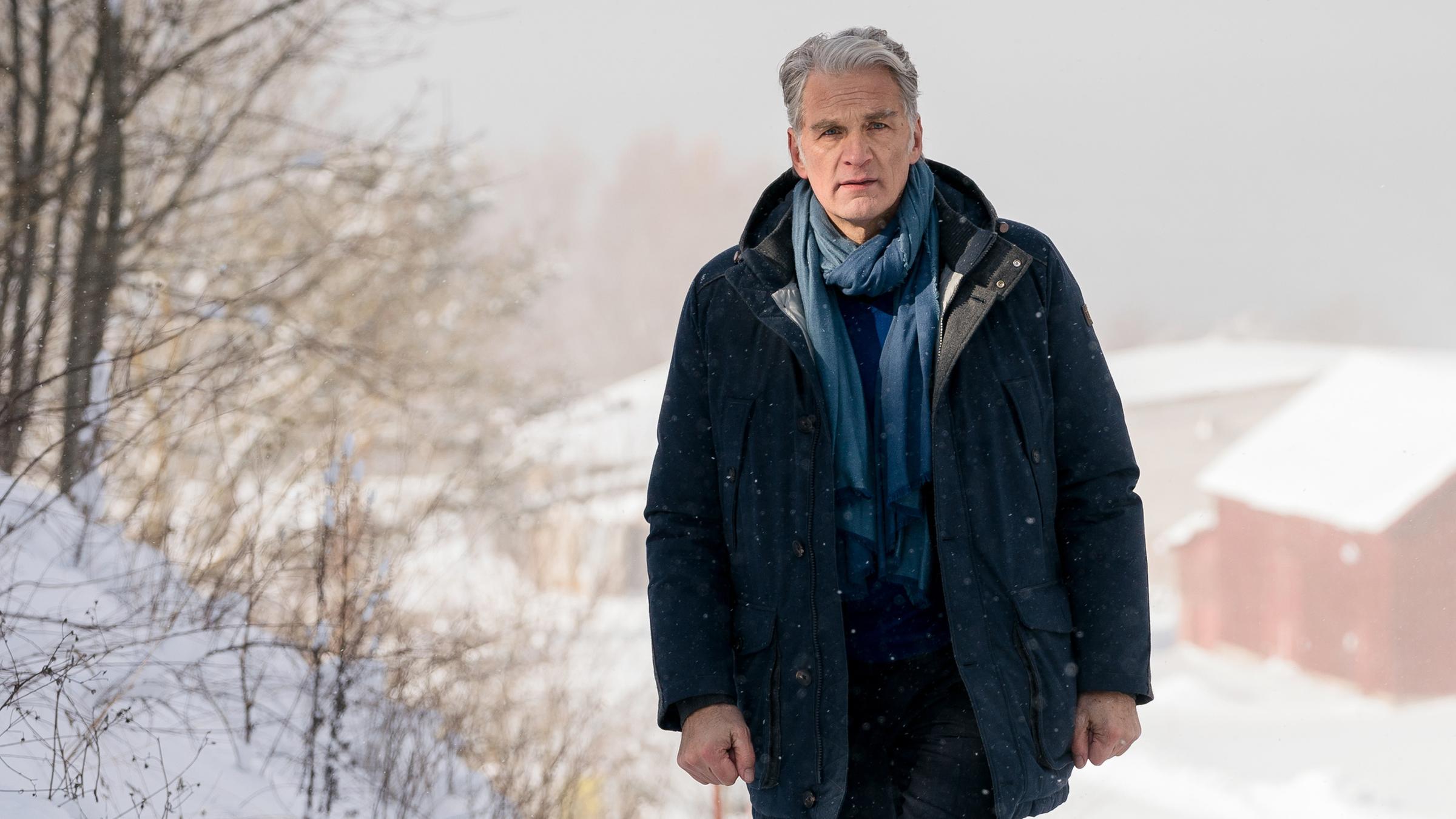  Robert Anders (Walter Sittler) läuft eine verschneite Straße entlang.