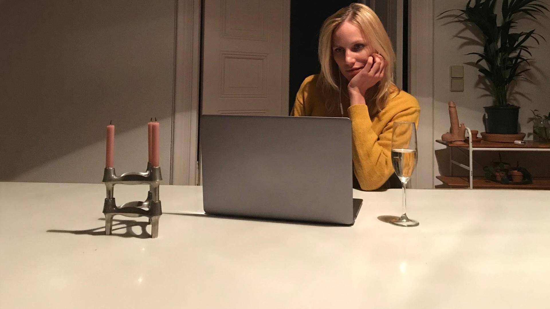 "Liebe. Jetzt! - Nachtschwärmer": Lena (Isabel Thierauch) sitzt am Tisch vor ihrem Laptop und schaut flirtend auf den Bildschirm.