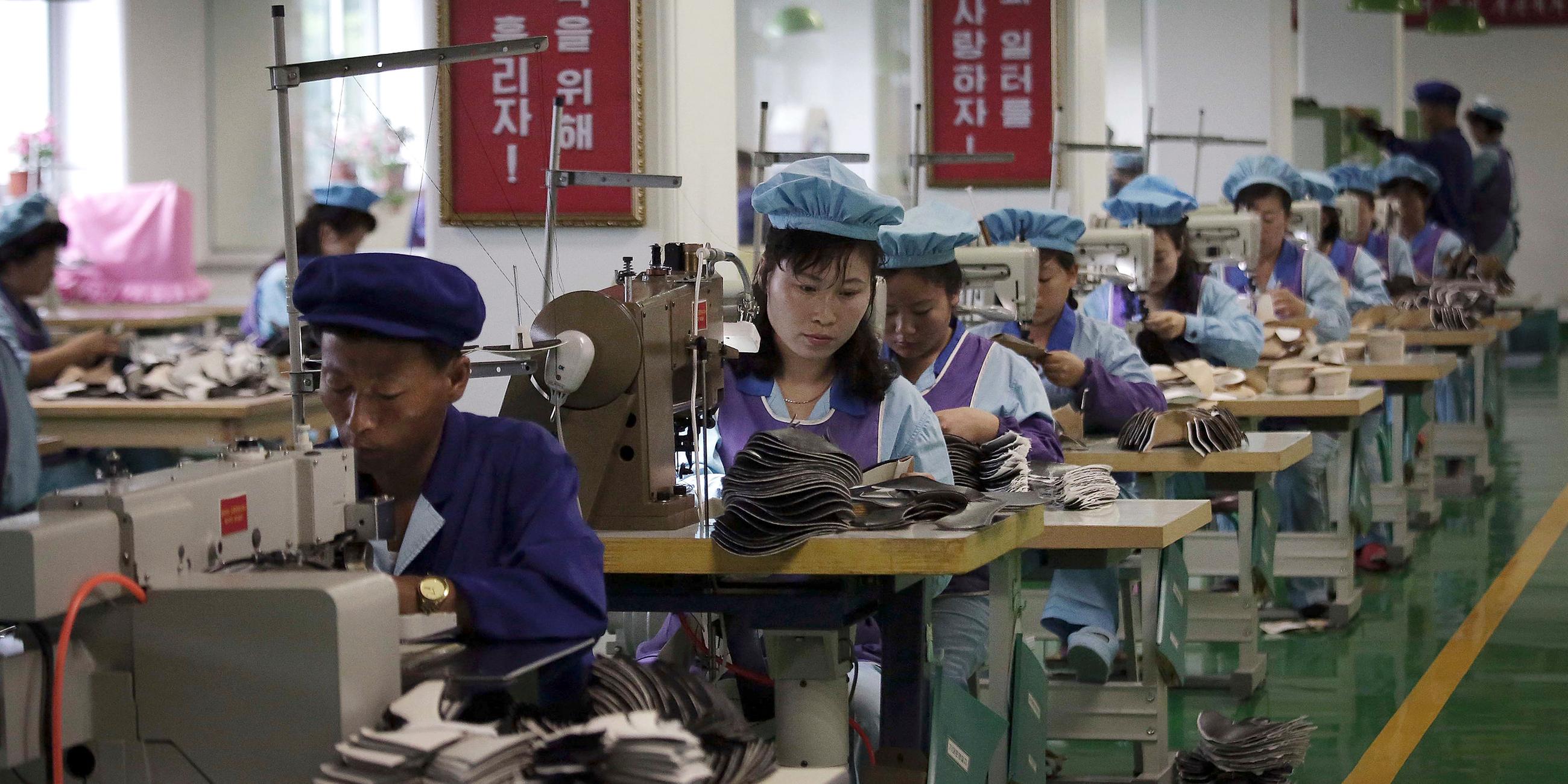 Fabrikarbeiter bedienen Nähmaschinen in einer Schuhfabrik in Wonsan, aufgenommen am 22.06.2016