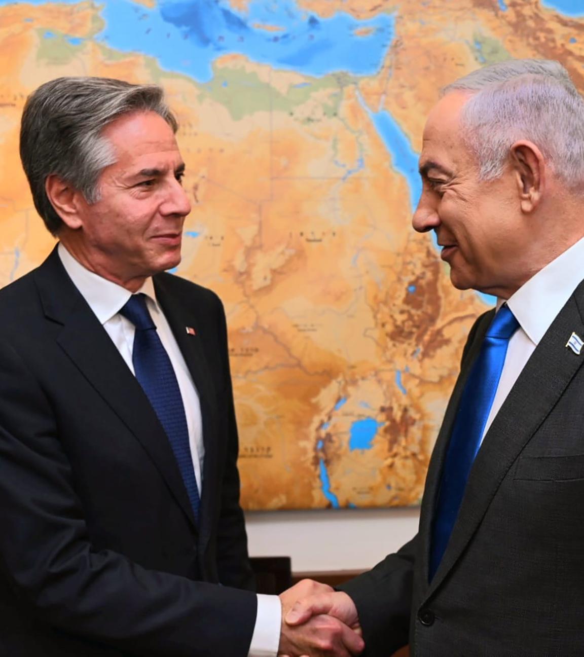 US-Außenminister Blinken beim Handshake mit Israels Premier Netanjahu vor einer Weltkarte.