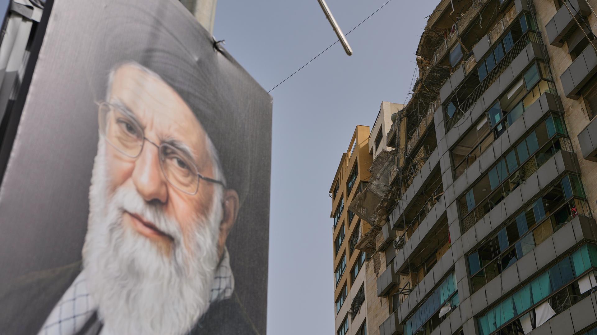 Ein Porträt des verstorbenen Ajatollah Ali Chamenei ist in der Nähe eines Gebäudes zu sehen, das bei einem israelischen Luftangriff in Dahiyeh, Libanon, beschädigt wurde.