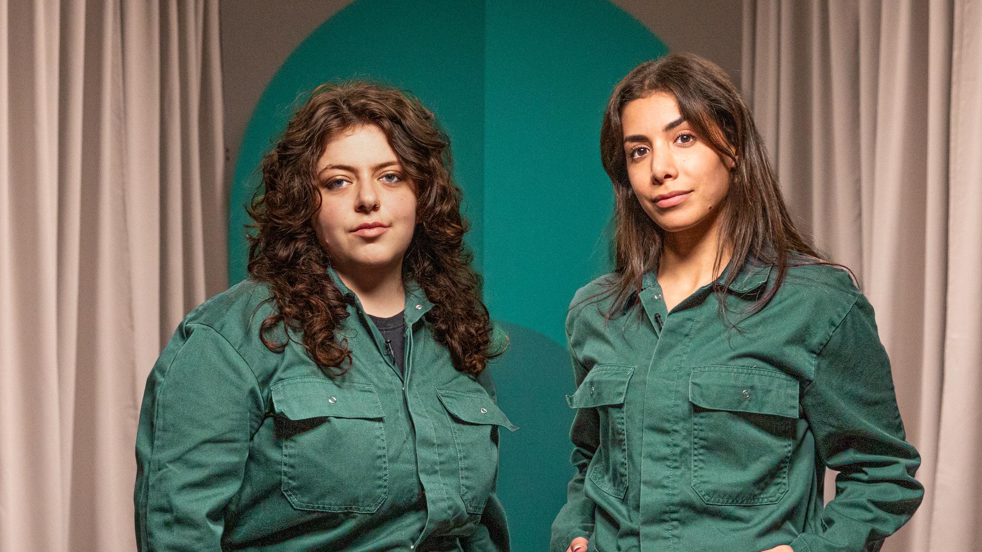 Die beiden Gäste der Folge in grünen Overalls.