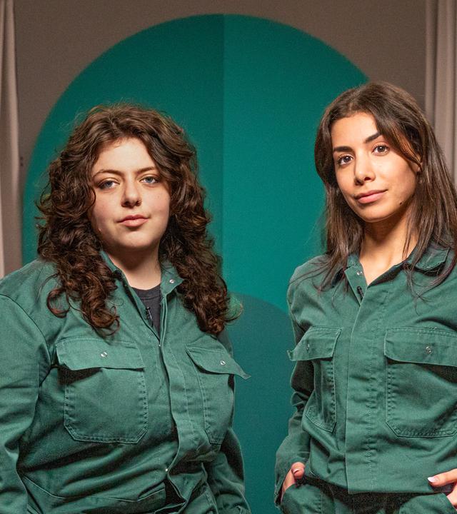 Die beiden Gäste der Folge in grünen Overalls.