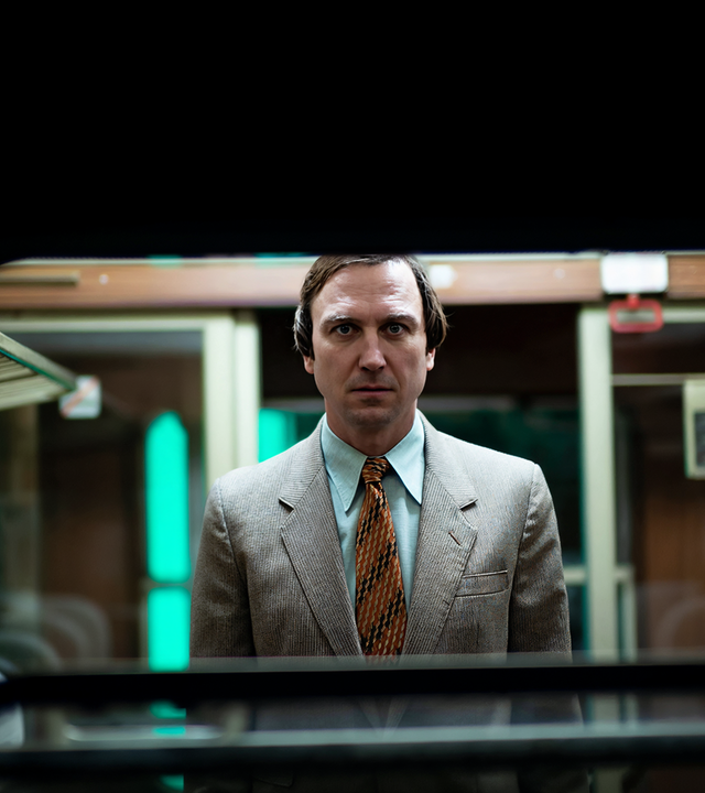 Franz Walter (Lars Eidinger) schaut frontal durch das Fenster eines Zuges